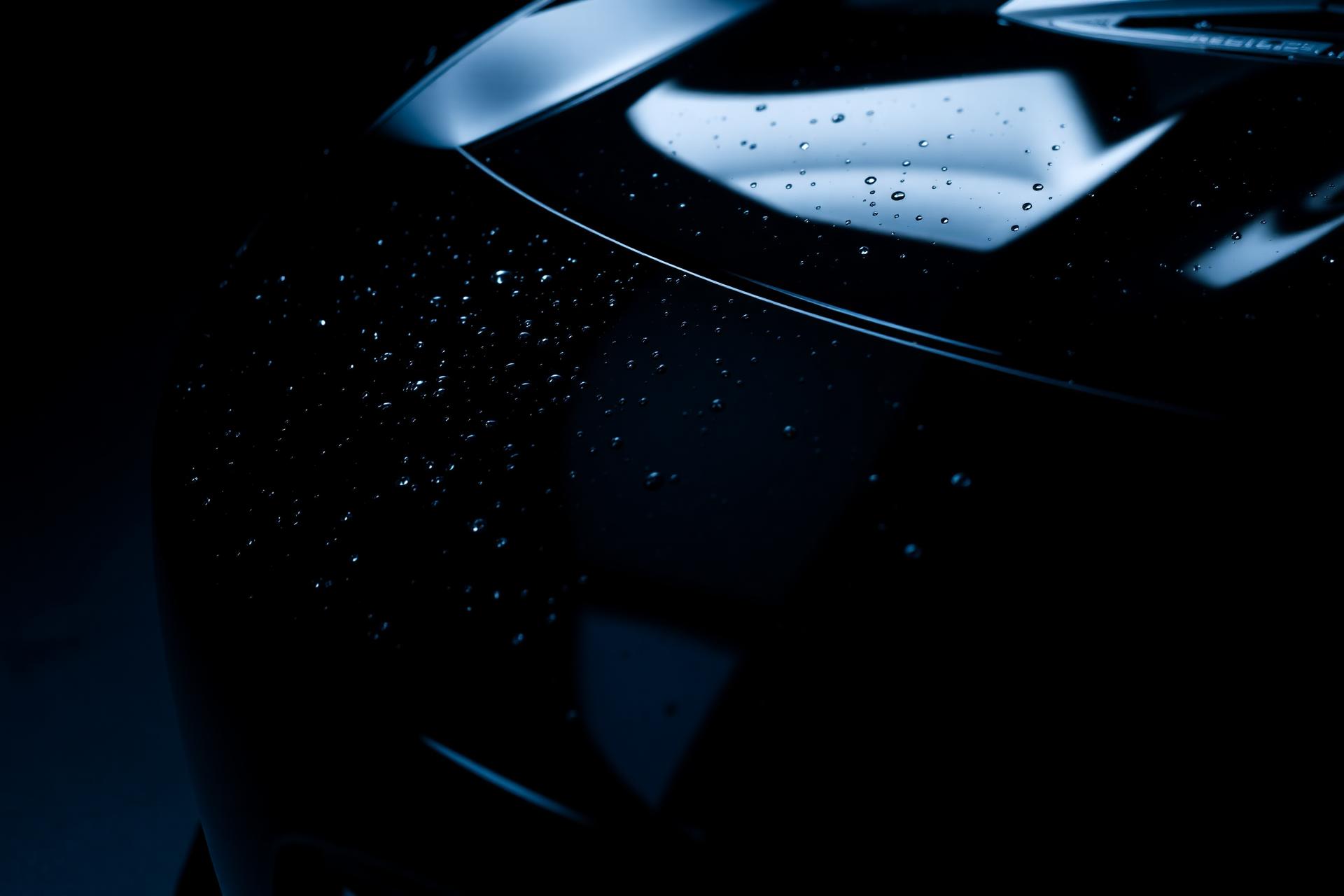 Glossy black luxury car with electric blue reflections